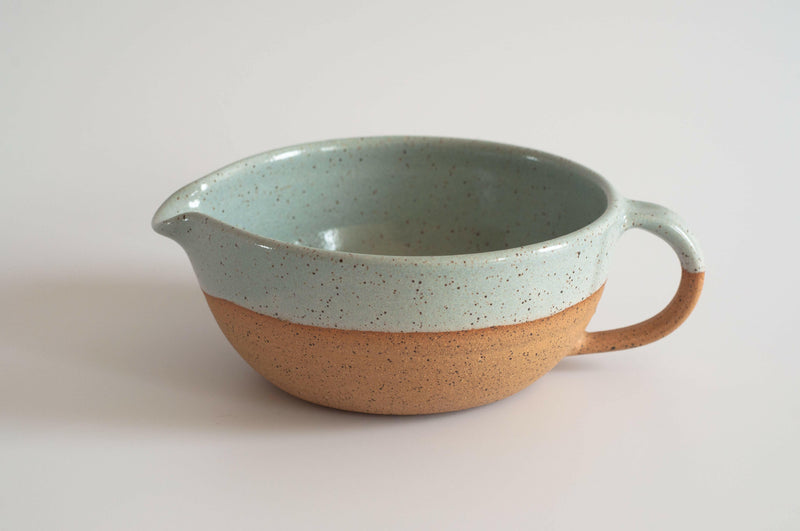 RachaelPots Salad Dressing Bowl - Nude; a versatile hand-thrown pottery piece with a garlic scraper, handle, and pour spout, perfect for dressings or guacamole.