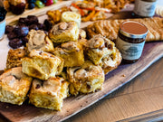 Rustic serving board with iced rolls and Southern Roots Sisters Maple Pumpkin Butter, ideal for enhancing fall cheese platters or breakfast dishes.