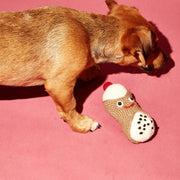 Ware of the Dog - Hand Knit Cannoli Dog Toy: A small dog sniffs a handcrafted, fair-trade lambswool toy with a smiling face, promoting ethical craftsmanship.