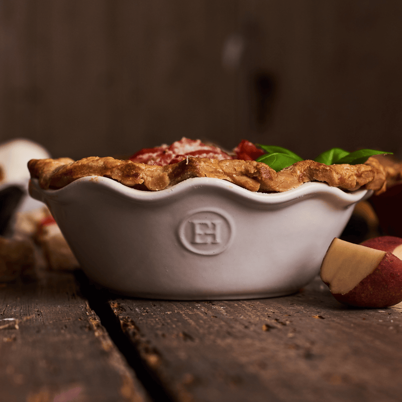 Emile Henry | Modern Classics Mini Pie Dish with savory pie, featuring a golden crust, tomato, cheese, and fresh basil, on a rustic wooden surface.