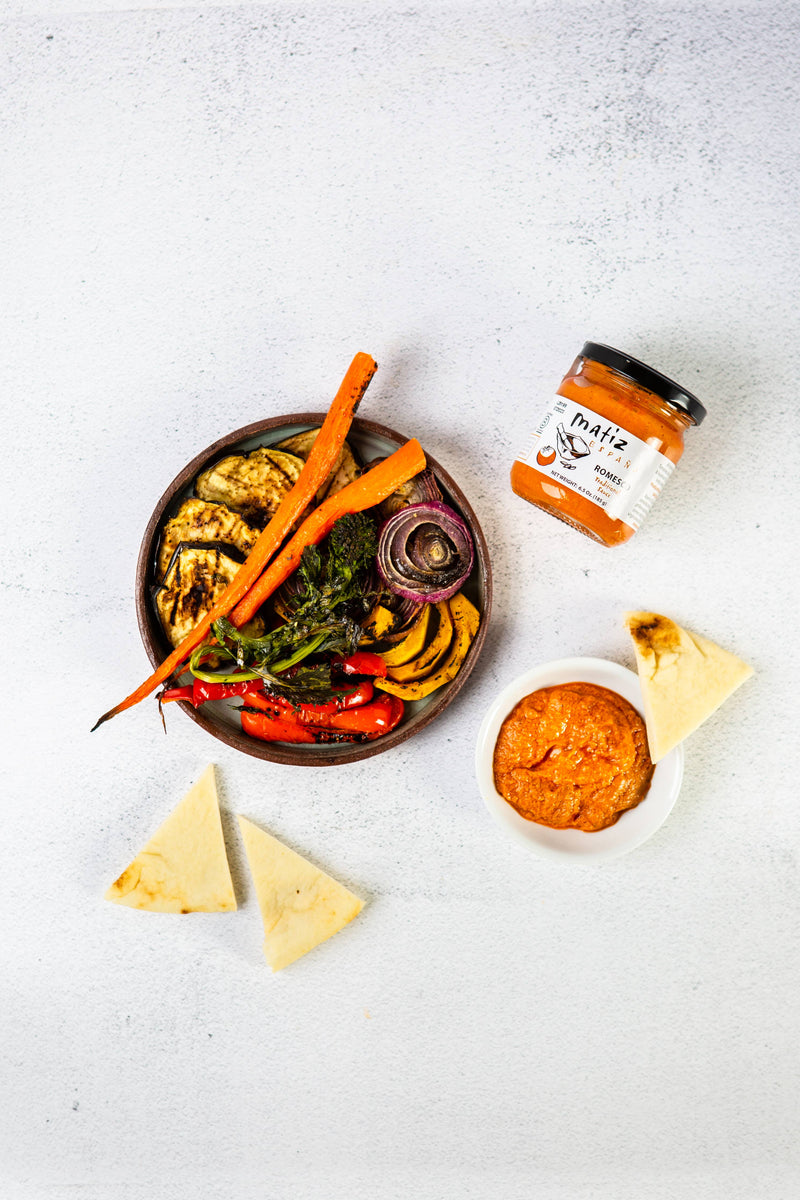 Matiz Romesco - 6.5oz with grilled vegetables, flatbread, and a jar of Matiz España Romesco Tradicional Sauce, perfect for dipping and enhancing Mediterranean dishes.