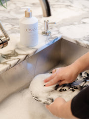 L'AVANT Collective Fresh Linen Dish Soap in a matte white bottle near a sink, highlighting its modern design and eco-friendly, high-performing formula.