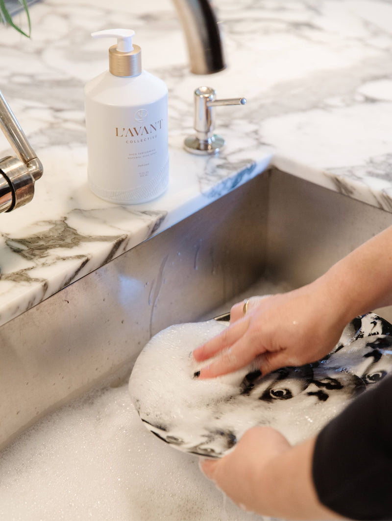 L'AVANT Collective Fresh Linen Dish Soap in a matte white bottle near a sink, highlighting its modern design and eco-friendly, high-performing formula.