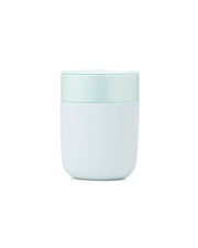 Reusable ceramic mug with a blue splash-resistant lid, featuring a silicone sleeve for grip. Ideal for coffee or tea, 16 oz capacity.