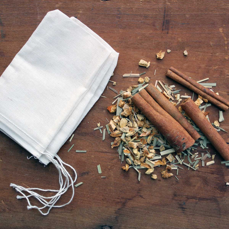 Oliver Pluff & Co. Lemon Ginger Hot Toddy Kit: Muslin bags on wood, ready for filling with cinnamon, citrus peel, lemongrass, ginger, and herbs for a soothing drink.