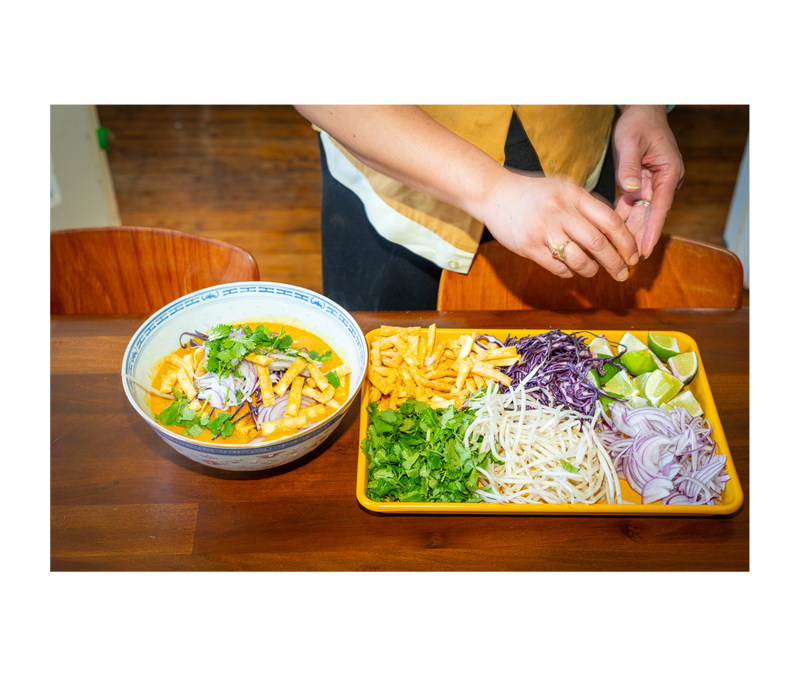 Close-up of a hand displaying the Great Jones | Little Sheet - Pepper, a quarter-sized baking pan ideal for small batches, showcasing its nonstick, nontoxic surface.