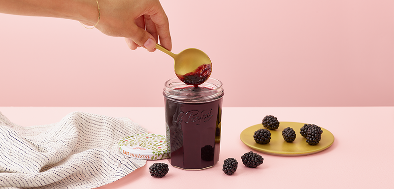 Le Parfait Faceted French Jam Jar, 324ml, with fruit jam, accompanied by blackberries and a gold spoon on a pastel-pink tabletop.