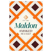 Wholesome Good - Maldon Smoked Sea Salt 4.4 oz package with distinctive diamond-patterned design, highlighting its cold-smoked oak flavor and delicate pyramid flakes for cooking versatility.