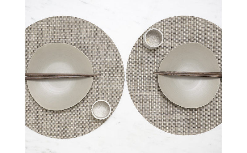 Chilewich | Mini Basketweave Round Placemats - Linen, featuring two plates with chopsticks, highlighting the refined placemat design on a woven surface.