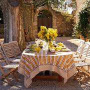 Couleur Nature - Provence Avignon Dijon & Blue Tablecloth: 71 x 106 draped on a wooden table with wine, flowers, and dessert in a charming courtyard.