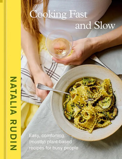 Cover of Penguin Random House LLC - Cooking Fast and Slow by Natalia Rudin, featuring a glass of white wine and leafy-green pasta, emphasizing (mostly) plant-based recipes for busy people.