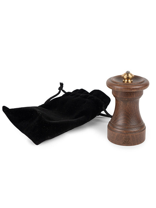 Peugeot | 1874 Manual Wooden Salt Mill Patinated, 4 inches, with brass knob, next to a soft velvet pouch, celebrating classic craftsmanship.