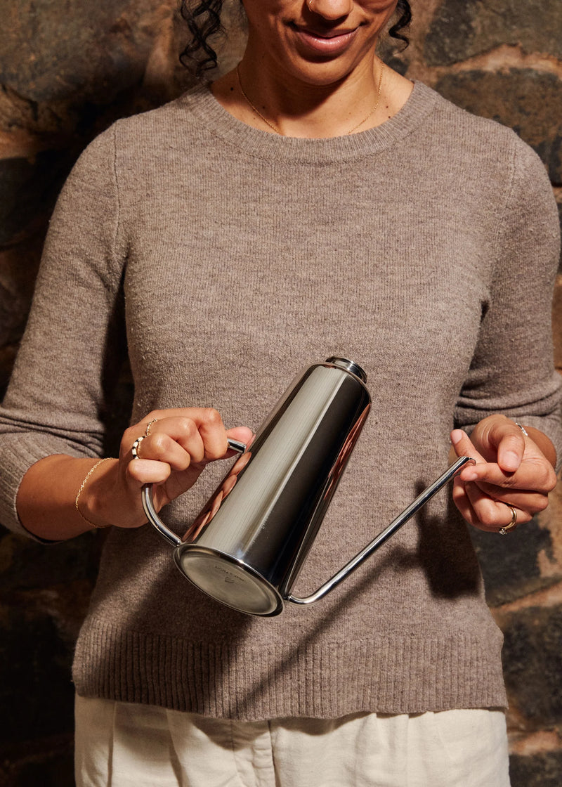 Holcomb Studio Oil Can held by a woman, featuring a sleek design with an elongated spout for precise, drip-free pouring, ideal for kitchen use.