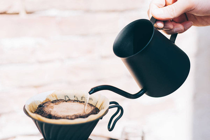 Hand pouring water with a black gooseneck kettle over the HARIO USA - V60 Metal Dripper: Silver, highlighting its precision brewing capabilities in a pour-over coffee setup.