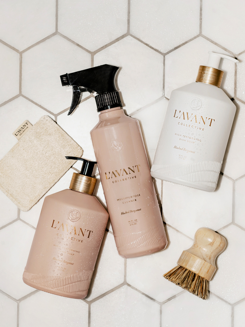 L'AVANT Collective - High Performing Hand Soap - Blushed Bergamot in blush pink bottle alongside a wooden brush and sponge, offering luxurious hand washing experience.