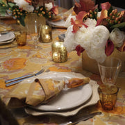 Close-up of Caravan Home - Pumpkin Orange & Mustard Tablecloth, elegantly set with autumn-themed décor, showcasing plates, napkin, and floral centerpiece for a warm dining experience.