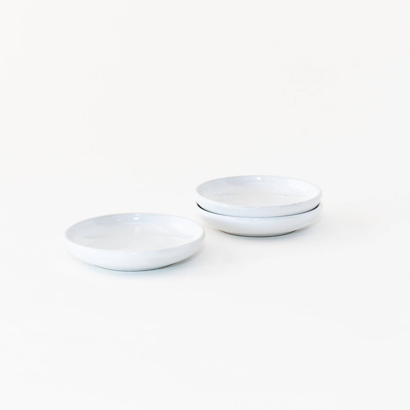 Sarah Kersten - Olive Dish: Basin Collection: Straw, featuring a stack of elegant, versatile white plates and bowls, perfect for appetizers or sides.