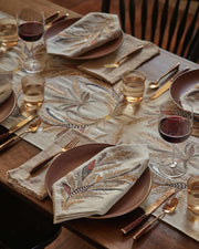Coral & Tusk - Wheat Harvest Dinner Napkin on an autumnal table with botanical motifs, earthen plates, and gold-tone flatware, embodying prosperity and abundance.