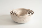 RachaelPots - Nesting Bowls Set Of Five: Light Blue, featuring stacked speckled stoneware bowls, ideal for versatile kitchen use, hand-thrown for unique character.