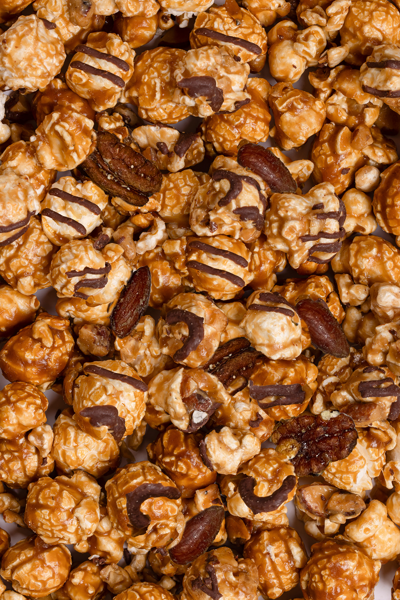 Poppy Hand-Crafted Popcorn - Reindeer Crunch Popcorn, featuring caramel-coated popcorn, dark chocolate drizzle, pecans, and almonds; a festive treat ideal for gifting.