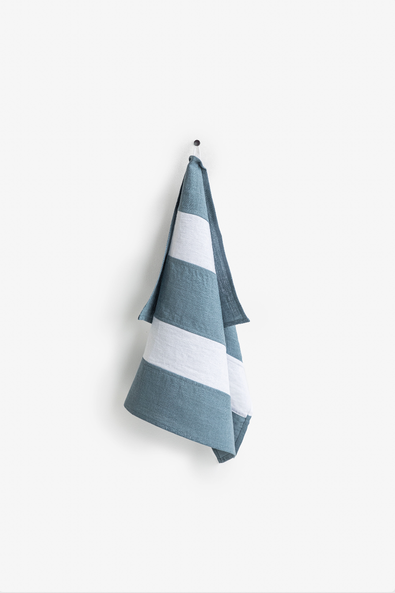 Striped linen tea towel on hook, showcasing durable, soft, zero-waste design with hanging loop from MagicLinen, ideal for enhancing kitchen interiors.