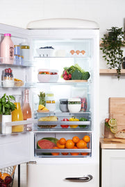 W&P - Glass Seal Tight To-Go & Storage Bowl: Cream / 16 oz, stored in a refrigerator full of various food items, showcasing its functionality for organized storage.