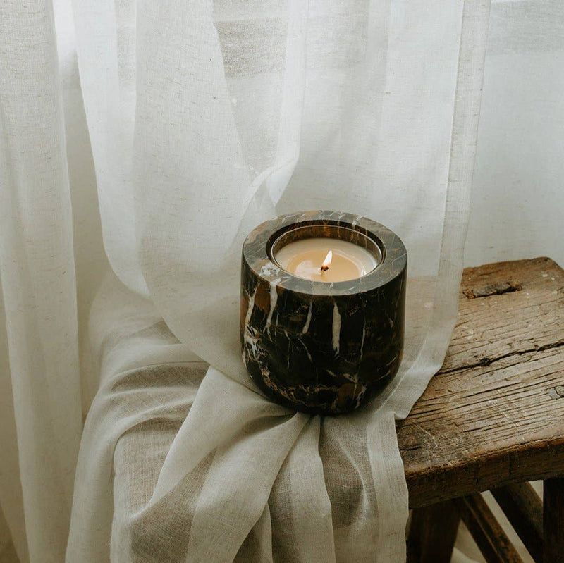 Last Candle Co - Portoro Marble Refillable Candle in a dark marble holder on light fabric, evoking warmth and minimalism, perfect for elegant kitchen decor.
