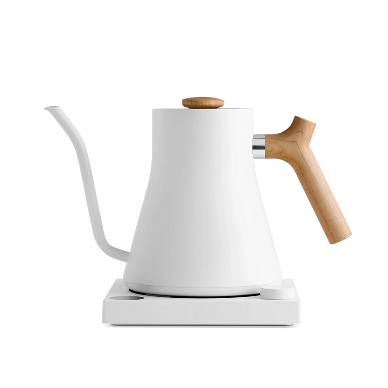 Fellow | Stagg EKG Electric Kettle, Matte White with Maple, featuring a minimalist design with a gooseneck spout, wooden handle, and matching heating base.