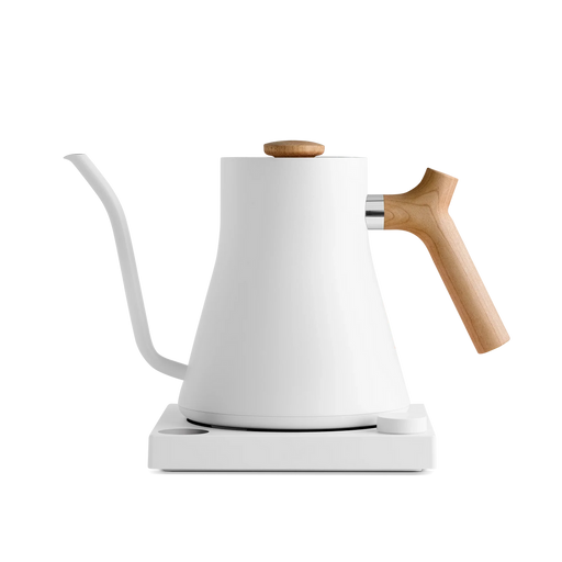 Fellow | Stagg EKG Electric Kettle, Matte White with Maple, featuring a minimalist design with a gooseneck spout, wooden handle, and matching heating base.
