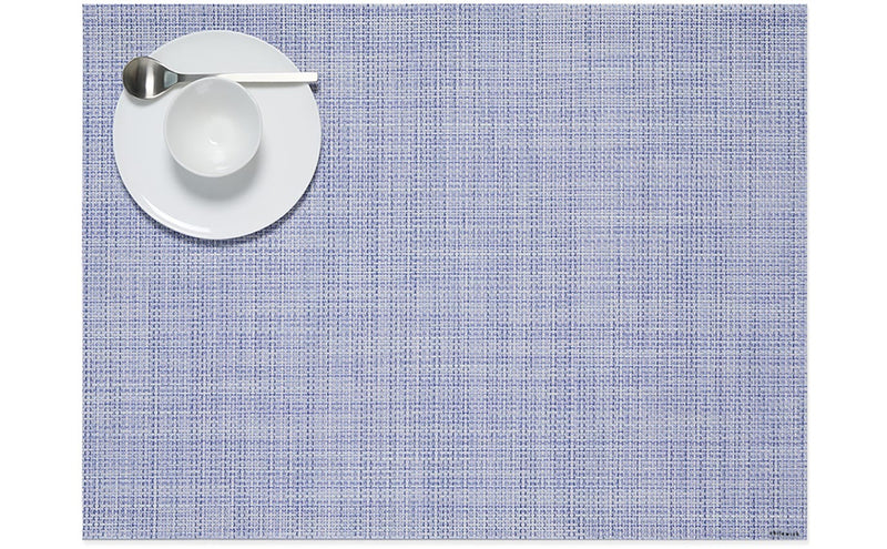 Chilewich Mini Basketweave Rectangle Placemat in use, featuring a plate with a white bowl and spoon, showcasing its elegant texture for dining settings.