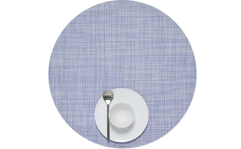 Chilewich | Mini Basketweave Round Placemat in Periwinkle displayed with a white bowl and spoon, highlighting its refined texture and elegant design for dining settings.