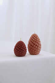 Mo&Co Home Exclusive: Sculpted Beeswax Pine Cones, featuring hand-poured pine-cone–shaped candles with textured scales, in two sizes, crafted for elegance and holiday nostalgia.