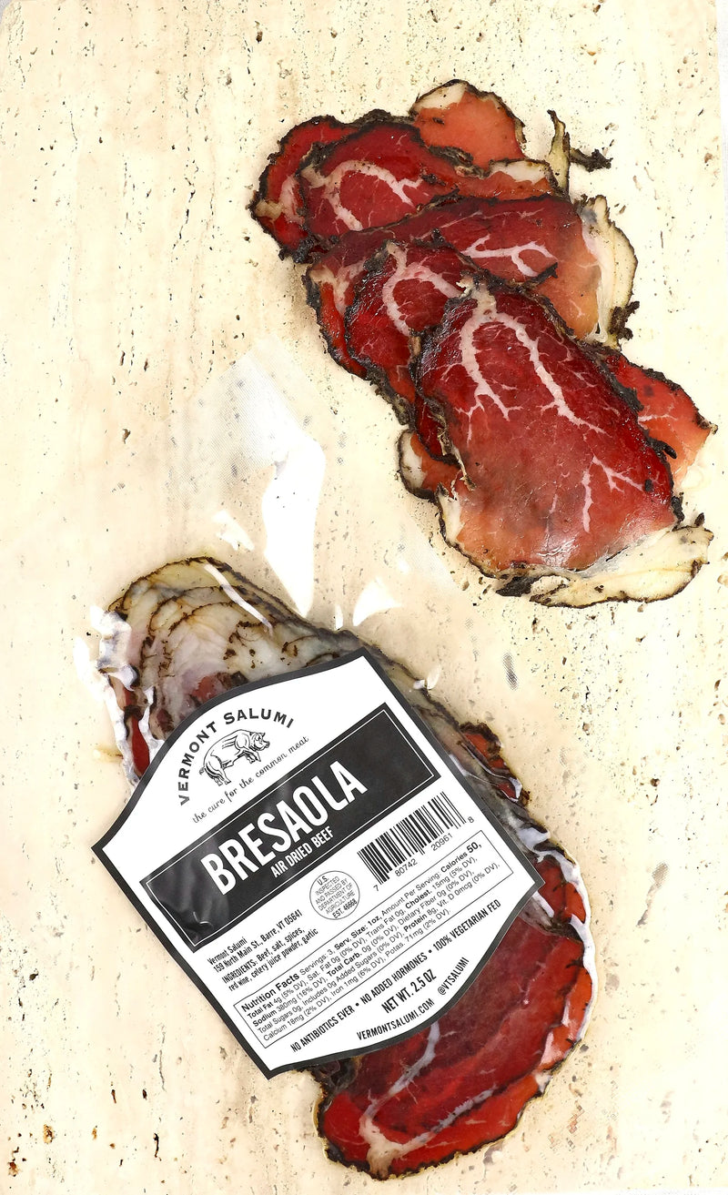 Vermont Salumi | Sliced Bresaola displayed in thin slices next to its packaging, showcasing air-dried, cured beef with thyme, juniper, and black pepper.