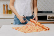 Bee's Wrap - Cut-to-Size Roll - Mushroom Magic, Limited Edition Print being cut on a kitchen counter, showcasing its versatility in sustainable, reusable food storage.