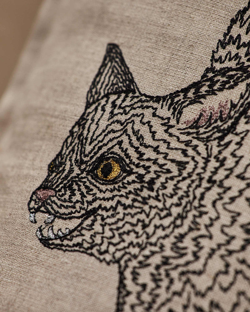Coral & Tusk - Scaredy Black Cat Pillow: Linen cover hand-embroidered with a snarling cat, showcasing sparkling gold eyes, perfect for playful Halloween decor. Measures 12 × 16.