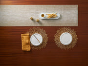 Chilewich | Bloom Placemats - Gilded on a dining table, elegantly displaying intricate openwork design, complementing a sophisticated table setting with plates and bread sticks.