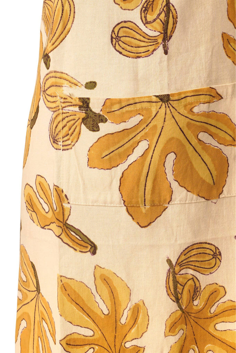 Close-up of Couleur Nature - Fig Citrine Apron, showcasing a handprinted fig-leaf pattern in mustard on a cream background, highlighting the artisan craftsmanship.