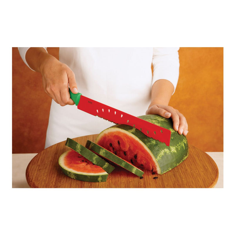 Kuhn Rikon | Original Melon Knife slicing through watermelon on a wooden board, showcasing its serrated blade and ergonomic handle for effortless cutting.