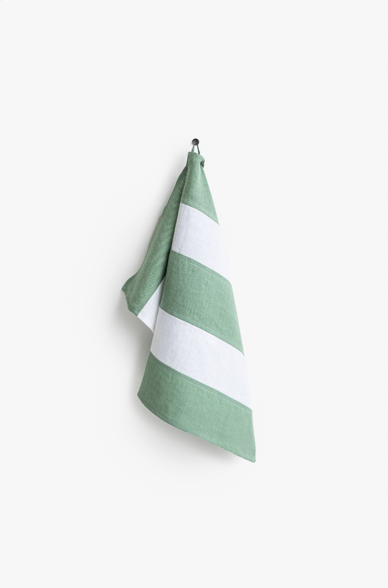 Striped linen tea towel on hook, part of MagicLinen's zero-waste collection, crafted for kitchen efficiency and style, featuring a hanging loop for convenience.