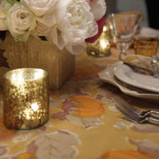 Autumn-themed table with Caravan Home - Pumpkin Orange & Mustard Tablecloth, gold vase, votive, and cream plates, reflecting Couleur Nature's artisanal craftsmanship.