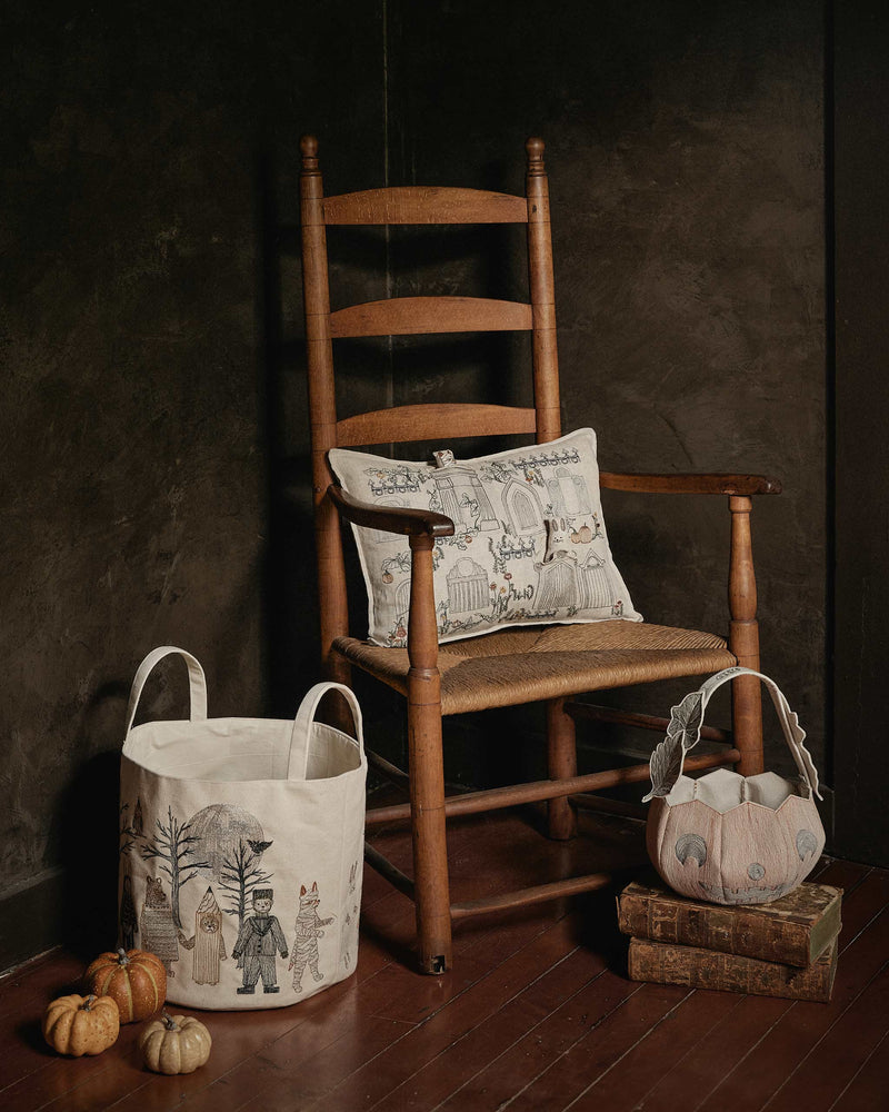 Coral & Tusk - Jack-o'-Lantern Basket with intricate embroidery, displayed in a rustic Halloween setting on vintage books, adds a handcrafted touch to festive décor.