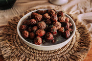 Southern Roots Sisters - Blackberry Pepper Jam showcased in a bowl, served on a straw placemat, highlighting its glossy sauce and herb garnish, perfect for diverse culinary uses.