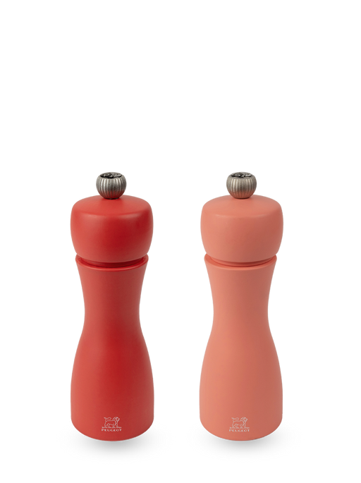 Peugeot | Tahiti Duo Salt + Pepper Mills, Fire: A matching set of red and coral-pink manual grinders, each with an adjustment knob and Peugeot lion logo.