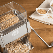 Marcato | Mill + Grain Crusher with hand crank, grinding whole grains into flour and flakes, featuring a clear hopper and collection tray, ideal for allergy-safe homemade cooking.