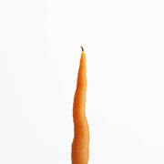 Artifaqt - Carrot Taper Beeswax Candle: Orange, shaped like a realistic carrot with a lit wick, showcasing its unique design and craftsmanship.