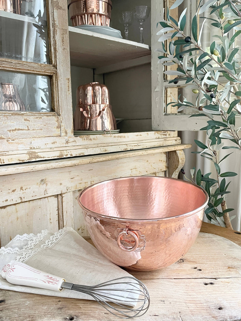 Coppermill Kitchen LLC - Coppermill Vintage Inspired Mixing Bowl, a hammered copper bowl with ring handle, showcased in a rustic kitchen setting, alongside a whisk and linen cloth.