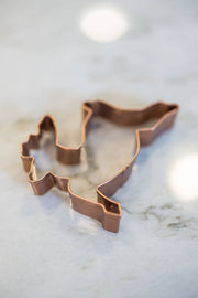 Galley and Fen - Christmas Cookie Cutters - Set of 6, featuring a Michigan-shaped copper cutter on a stone countertop, perfect for festive baking.