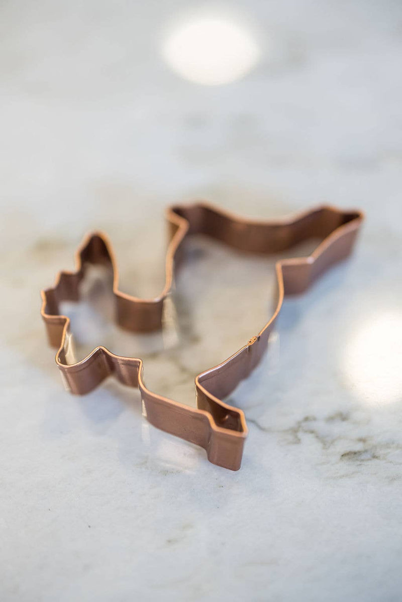Galley and Fen - Christmas Cookie Cutters - Set of 6, featuring a Michigan-shaped copper cutter on a stone countertop, perfect for festive baking.