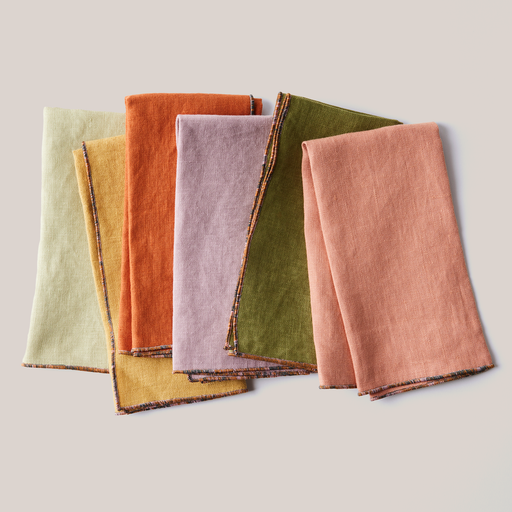 ATELIER SAUCIER - Mix-and-Match Chroma Napkins | Set of 6: A neatly folded set of six colorful linen napkins with multicolored stitched borders, enhancing any dining experience.