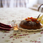 Couleur Nature - Gooseberry Red & Green French Tablecloth elegantly sets a festive dining scene with a king's cake and candle, inviting warmth for family gatherings.